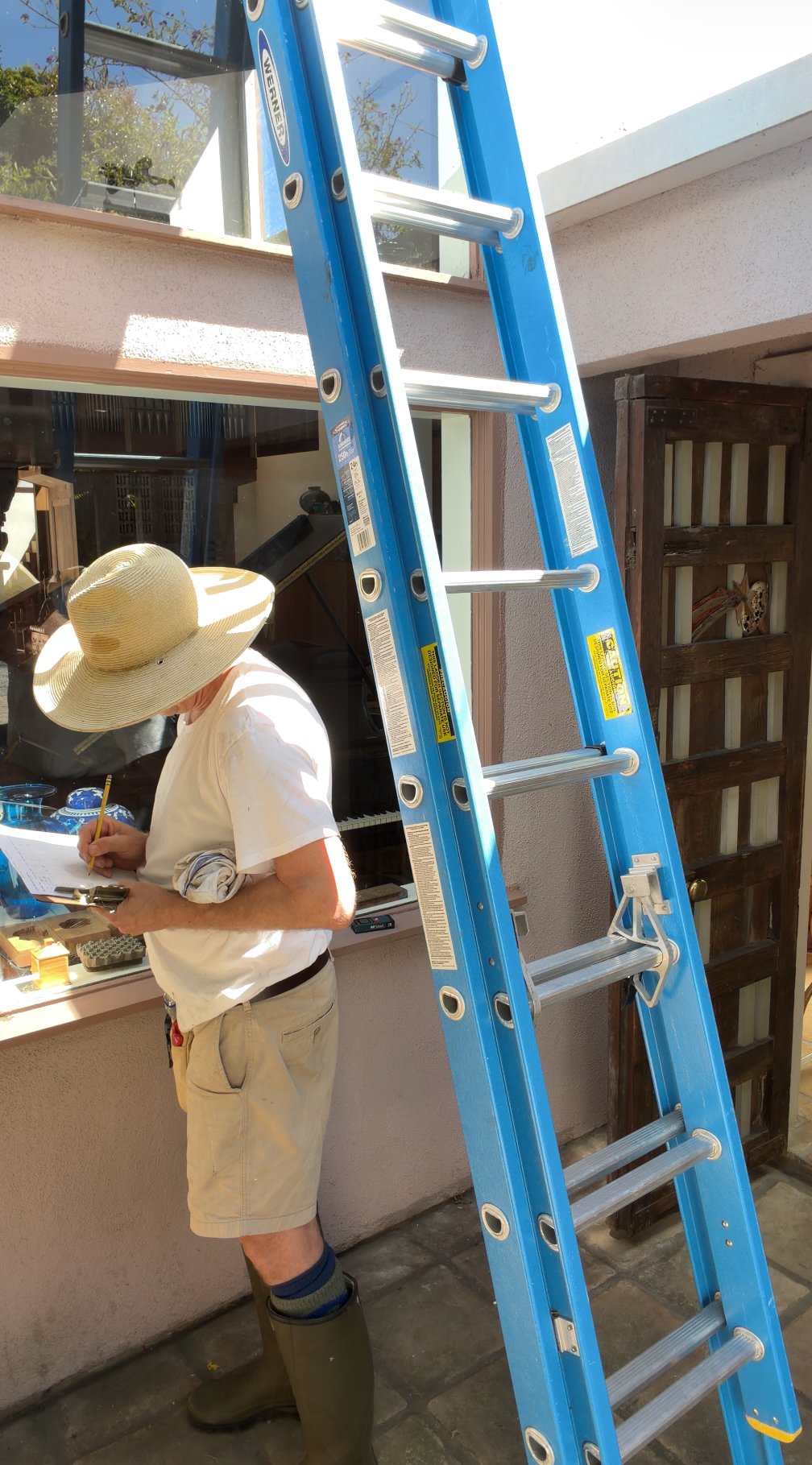 Kevin assessing a window from the ladder